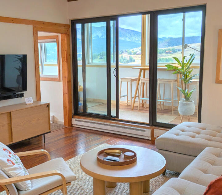 Open living room with couch, dining table, and kitchen in a two-bedroom Mt. Crested Butte condo rental