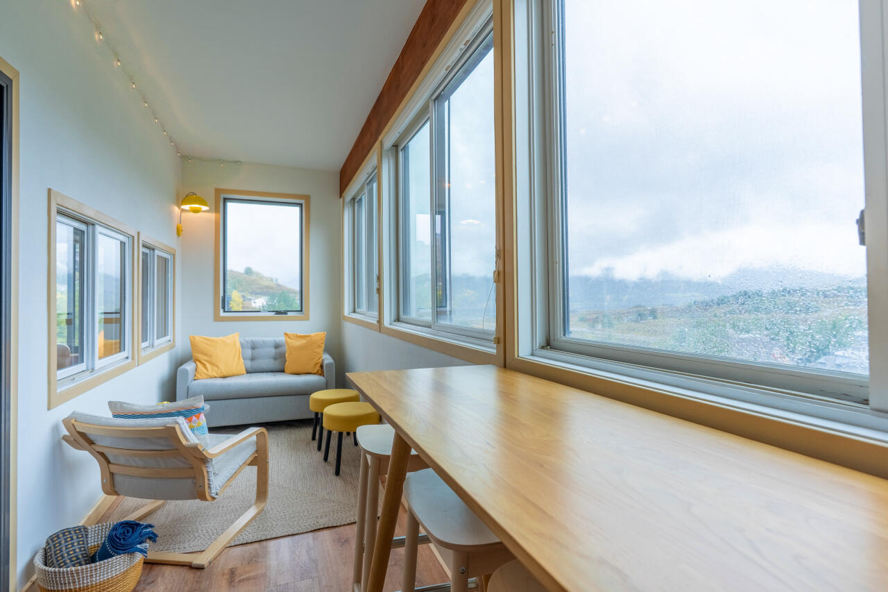 Sunroom of a Mt. Crested Butte vacation rental condo with large windows looking out on the mountains on an overcast day